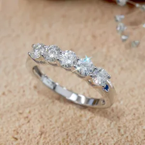 Nahaufnahme eines klassischen Fünf-Stein-Rings mit funkelnden runden Moissanit-Edelsteinen.