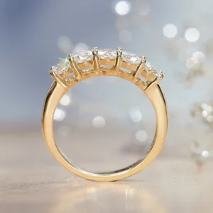 Nahaufnahme des eleganten Fünf-Stein-Moissanit-Rings mit poliertem Goldband im Detail.