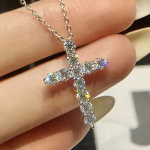 Detailed view of exquisite moissanite cross pendant necklace, silver clavicle chain jewelry.