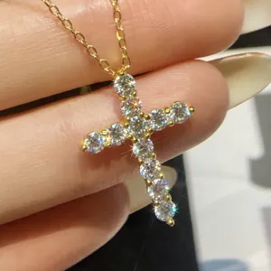 Exquisite moissanite cross pendant necklace detail, sparkling pave stones on gold chain.