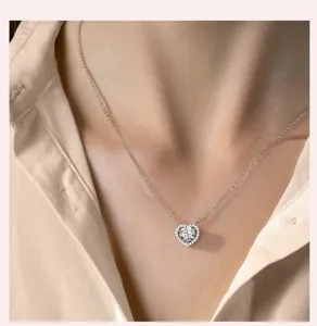 Gros plan d'un collier pendentif cœur scintillant porté élégamment sur le décolleté.