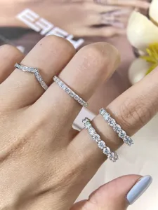 Nahaufnahme von Sterling Silber Moissanit Eternity Ringen und V-Band an der Hand.