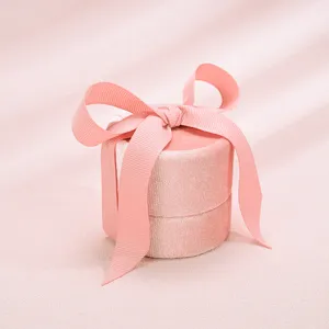 Elegant pink velvet ring box featuring a charming ribbon bow, perfect for jewelry presentation.