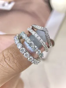 Nahaufnahme Detail von silbernen stapelbaren Moissanit Ewigkeitsringen am Finger.