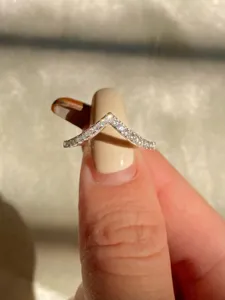 Nahaufnahme Detailaufnahme eines glitzernden V-förmigen Moissanit Ringes am Finger.