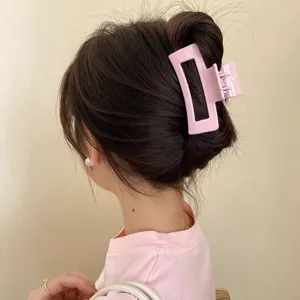 Détail pince à cheveux rose, accessoire géométrique mignon pour coiffure élégante quotidienne.