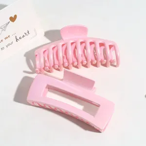 Vue détaillée de la pince à cheveux rose, montrant clairement le design nacré et ajouré.