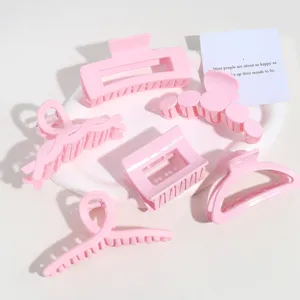 Détail de pinces à cheveux roses, accessoires mignons pastel pour coiffure femme.