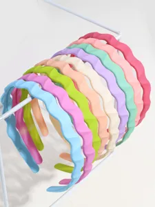 Vue détaillée de serre-têtes en plastique ondulé coloré disposés sur un support blanc.