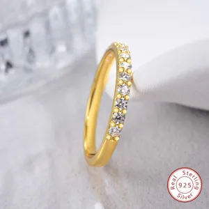Nahaufnahme eines vergoldeten Sterlingsilberrings mit einer Reihe funkelnder Steine.