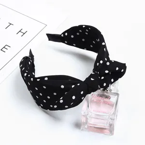 Black polka dot bow headband for women, stylish fabric hair hoop with cute design.
