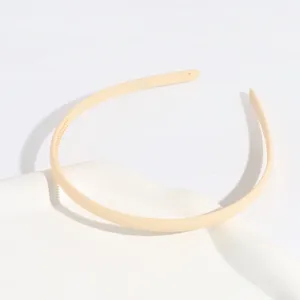 Close up of a thin plastic hair hoop in apricot color, showing delicate anti-slip teeth detail.