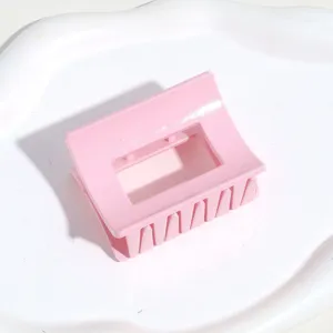 Pince à cheveux rose pour femme, accessoire de coiffure rectangulaire en plastique vue détail.