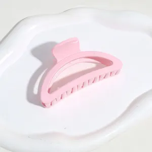 Vue de détail rapprochée de la pince à cheveux rose avec une forme d'arc et des dents.