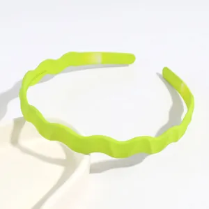 Serre-tête ondulé en plastique vert, design simple et élégant pour le quotidien et le soin.