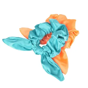 Satin hair scrunchie with bunny ears knot, vibrant teal and orange colors for styling.