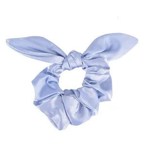 Close-up detail of a light blue satin hair scrunchie with cute bunny ear knot design.