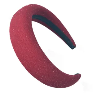 Gros plan du serre-tête large rouge pailleté avec une texture de tissu rembourré.