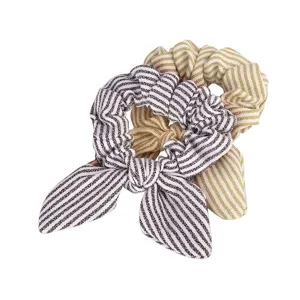 Detailed close-up of striped satin scrunchies with cute bunny ear knot, elastic hair ties.