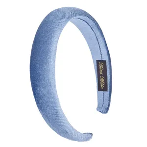 Close-up detail of a light blue velvet padded hair hoop, showcasing soft fabric and fine handmade label.