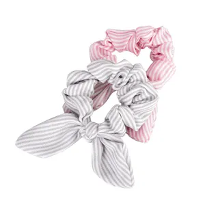 Detailed view of striped hair scrunchies featuring a pink classic band and grey bunny ear tie.