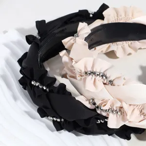 Detail shot of wide solid color rhinestone ruffle headband, elegant fashion hair accessory.