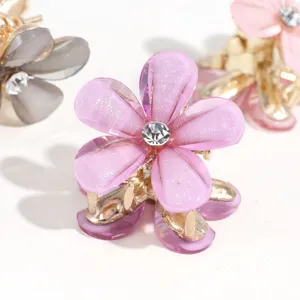 Mini flower hair claw clip detail view showing shiny resin petals and sparkling rhinestone center.