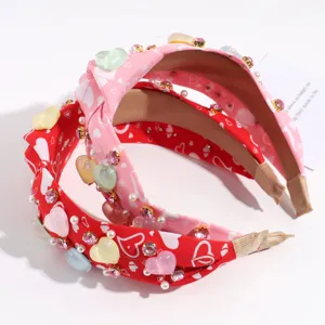 Detailed view of fashionable heart headband with crystal and pearl embellishments, pink and red.