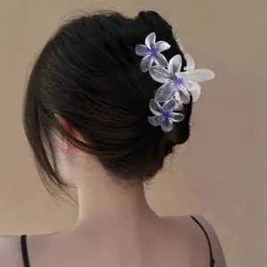 Primo piano dettagliato della pinza per capelli a fiore sfumato trasparente sul retro.