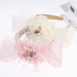 Detailaufnahme des eleganten Schleifen-Haarbandes mit Tüllblüte und funkelnden Strasssteinen.