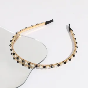 Detailed view of the Korean style gold-tone chain headband decorated with pearls and black beads.
