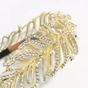 Gold feather hair hoop detail close up showing sparkling rhinestones and elegant pearls.