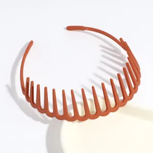Detail shot of brown plastic multi-tooth hairband, anti-slip design for everyday wear.