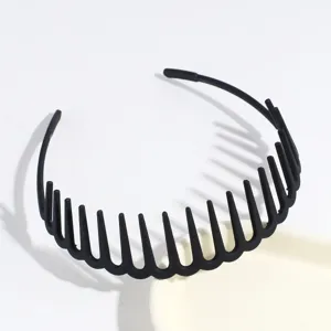 Close-up detail of a black plastic comb headband with teeth design for secure hair styling.