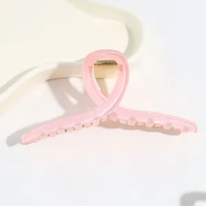 Nahaufnahme Detail einer minimalistischen rosa transparenten Haarklammer mit glänzendem Finish.