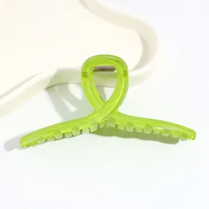 Nahaufnahme der transparenten grünen Twist Haarspange mit glänzender Oberfläche und Feder.