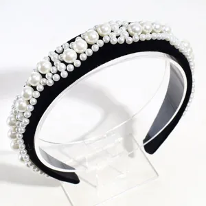 Vista detallada de elegante diadema de terciopelo negro adornada con perlas, accesorio chic.