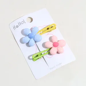 Primer plano detallado de lindas pinzas para el cabello con flores coloridas en tarjeta.