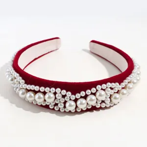 Vista detallada de la elegante diadema de terciopelo rojo con perlas y tela suave.