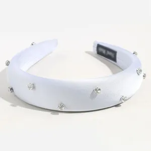 Vue détaillée du serre-tête rembourré en satin blanc avec des strass et cristaux.