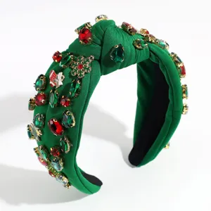 Closeup detail of green fabric knotted Christmas rhinestone crystal hair hoop headband.