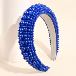 Primo piano dettagliato di un cerchietto per capelli blu largo con perle finte e tessitura.