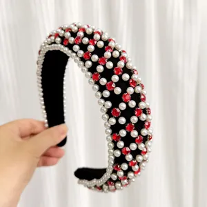Cerchietto largo in spugna nera decorato con perle bianche e strass rossi luminosi.