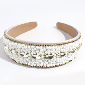 Detailed view of wide white beaded headband with sparkling rhinestones and colorful gemstone trim.