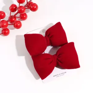 Close-up detail of the red velvet bow hair clip showcasing soft texture and exquisite card packaging.