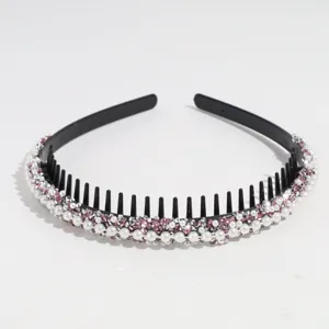 Primo piano di un cerchietto nero con denti, decorato con perle e strass scintillanti.