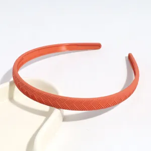 Dettaglio cerchietto in plastica arancione, superficie testurizzata diagonale, accessorio