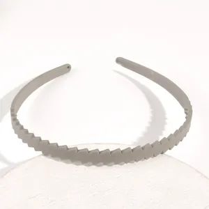 Primo piano del cerchietto per capelli in plastica grigia con motivo diagonale, dettaglio.