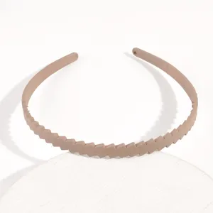 Primo piano dettagliato del cerchietto in plastica beige chiaro con motivo diagonale, accessorio.
