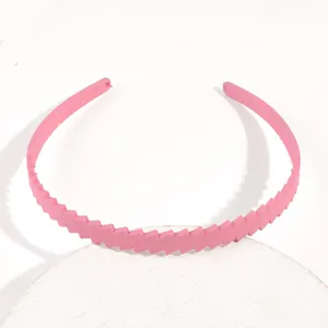 Dettaglio cerchietto rosa in plastica, sottile fascia per capelli con motivo a righe.